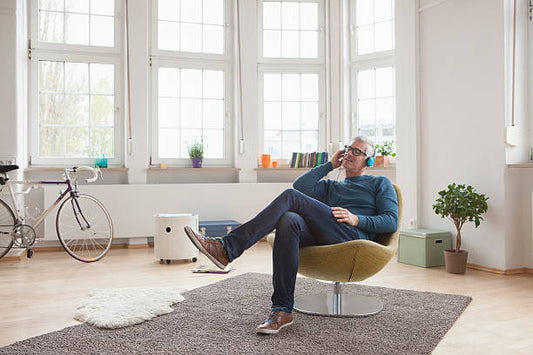 Personne installée confortablement dans un intérieur lumineux, en train de se détendre. Une scène calme et chaleureuse qui évoque le repos comme maniere de recharger les batteries.