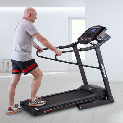 Homme montant sur le tapis de course Pioneer G6484H en se tenant aux barres de maintien latérales, accès arrière bas