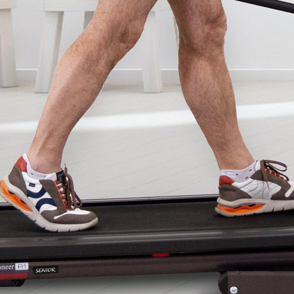 Gros plan sur les pieds en marche sur la surface antidérapante du tapis de course Pioneer G6484H