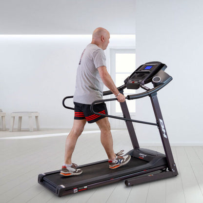 Homme en marche sur le tapis de course Pioneer G6484H, vue latérale avec barres de maintien et console digitale