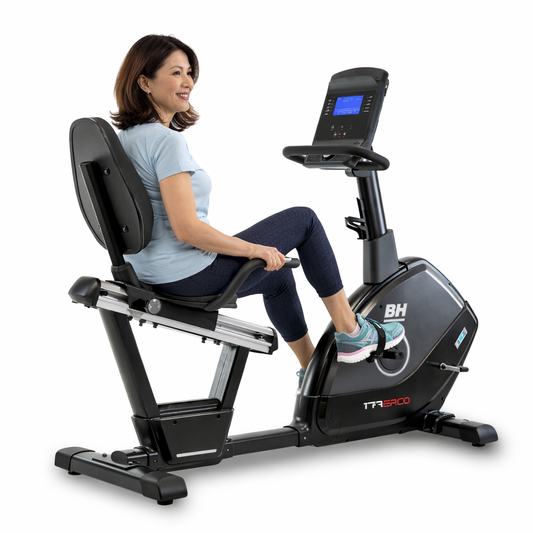 Vélo semi-allongé Ergo Med BH Fitness avec utilisatrice, vue de dos trois quarts, dossier XXL et cadre ouvert